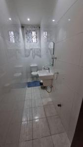 a white bathroom with a sink and a toilet at Natako Apartment in Apenkwa +26 photos