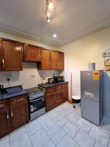 a kitchen with wooden cabinets and a stainless steel refrigerator at Natako Apartment in Apenkwa