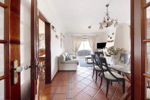 a dining room and living room with a table and chairs at Live Vagueira Beach in Praia da Vagueira