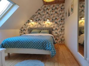 1 dormitorio con 1 cama con edredón azul en Appartement indépendant avec extérieur, en Epfig