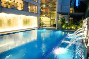 a large swimming pool in a building with a fountain at Lakeshore Heights in Dhaka