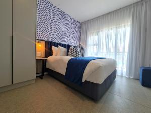 um quarto com uma cama e uma grande janela em MINT Resorts The Blyde em Pretoria