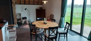 a dining room with a wooden table and chairs at Schaapskooi Sandenburg in Doorn