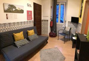 uma sala de estar com um sofá e uma cadeira em Lisbon T2 apartment in typical villa in Sapadores Lisbon em Lisboa