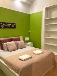 um quarto verde com uma cama com duas toalhas em Lisbon T2 apartment in typical villa in Sapadores Lisbon em Lisboa