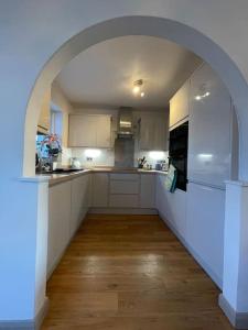 a kitchen with an archway in the middle of it at Charming North Norfolk flint cottage in Baconsthorpe