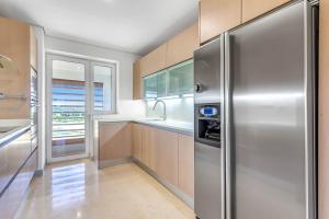 una cocina con refrigerador de acero inoxidable en Ribera del Marlin Atico/Penthouse, en Sotogrande
