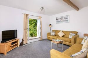 sala de estar con sofá y TV en Church House Barn Lake District & Solway Coast with Solway Firth views, en Silloth