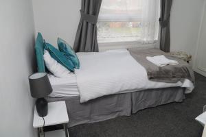 ein kleines Bett in einem Zimmer mit Fenster in der Unterkunft Superb 3 Bedroom flat in Stafford in Stafford