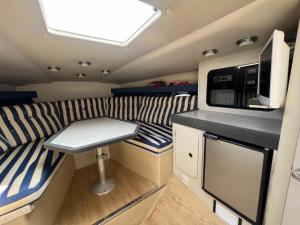 an interior of a rv with a table and a microwave at Barco Frapé in Barcelona