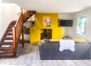 sala de estar con sofá y pared amarilla en Shannon Castle Holiday Cottages - Type D 