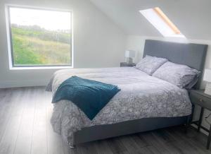 um quarto com uma cama grande e uma janela em Shannon Castle Holiday Cottages - Type D 