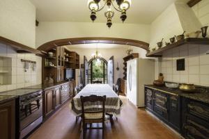 a kitchen with a table and a dining room at Can Mariné in San Antonio de Vilamajor