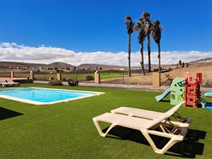 a pool with a lounge chair and a playground at Villa Yeromi in La Guirra