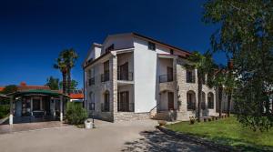 un grand bâtiment blanc avec un arbre dans l'établissement B&B Moderno, à Fažana