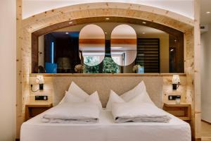 ein Schlafzimmer mit einem großen Spiegel über einem Bett in der Unterkunft Hotel Klosterbräu in Seefeld in Tirol