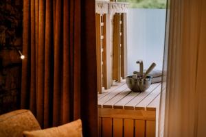einen Holztisch mit einer Schüssel Geschirr am Fenster in der Unterkunft Hotel Klosterbräu in Seefeld in Tirol