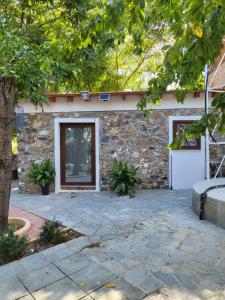 een stenen huis met een deur en een stenen patio bij Kallithea INN in Platres