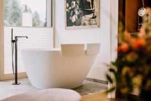 ein Bad mit einer großen weißen Badewanne in einem Zimmer in der Unterkunft Hotel Klosterbräu in Seefeld in Tirol