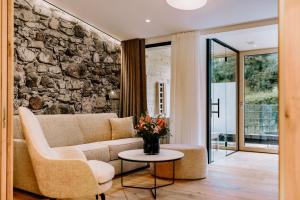 ein Wohnzimmer mit einem Sofa und einer Steinmauer in der Unterkunft Hotel Klosterbräu in Seefeld in Tirol