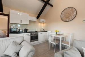 a kitchen with a table and a clock on the wall at Cornflower in Saundersfoot