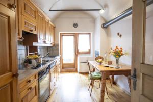 cocina con armarios de madera y mesa de madera en Chasa Broel Ferienhaus mitten in Ardez en Ardez