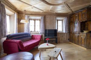 sala de estar con sofá rojo y TV en Chasa Broel Ferienhaus mitten in Ardez, en Ardez