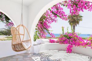 a room with a swing and pink flowers at KAMEO, Antiparos in Antiparos