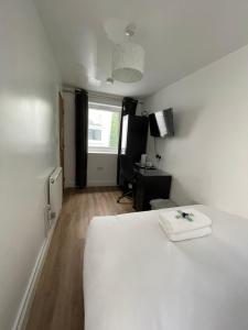 a bedroom with a white bed and a desk at Blackheath Stay in London