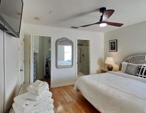 a white bedroom with a bed and a ceiling fan at Casa Mar Y Palmera 202a in Clearwater Beach