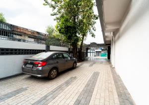 un coche aparcado en un aparcamiento al lado de un edificio en Treebo Trend Kaveri, en Nashik