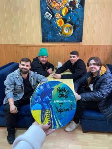 a group of men sitting on a couch holding a globe at АРТ-ВОКЗАЛ in Kryvyi Rih