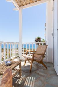 a porch with a table and a bench and the ocean at KAMEO, Antiparos in Antiparos
