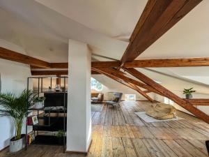 una sala de estar en el ático con techos de madera y suelo de madera. en Loft-Wohnung im Herzen von Prien - 100m2 - SmartTV en Prien am Chiemsee