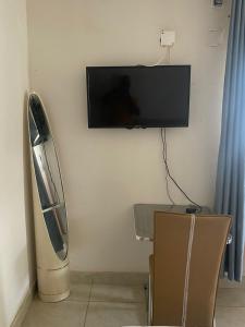um quarto com uma televisão de ecrã plano na parede em Aeropark Residencial(1) em Maputo