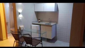 a kitchen with a glass table and two chairs at Hotel Hot Springs 528 in Caldas Novas