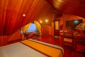 a bedroom with a bed and a desk and a television at NRS Norling Retreat in Darjeeling