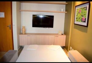 a room with a table and a flat screen tv at Hotel Hot Springs 528 in Caldas Novas