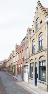 una fila de edificios de ladrillo en una calle de la ciudad en Two White Pigeons, en Ypres