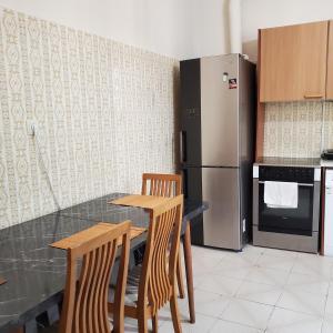 a kitchen with a table and chairs and a refrigerator at HOME away from home_3BR at Maniatika_14min walk to the port in Piraeus