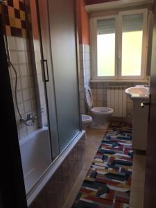 a bathroom with a tub and a toilet and a rug at Affittacamere Ferranti di fronte al Centro di Selezione in Foligno