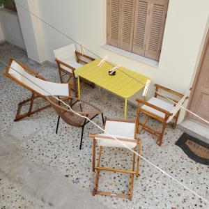 a group of chairs and a yellow table and chairs at HOME away from home_3BR at Maniatika_14min walk to the port in Piraeus