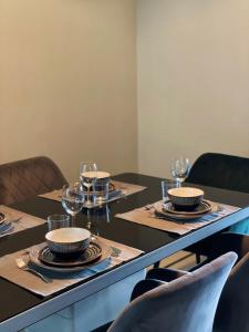 een eettafel met borden en wijnglazen bij Deluxe Cosmopolitan Apartment Budapest, with Private Parking in Boedapest