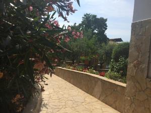 a garden with pink flowers and a stone wall at Apartments Mirela in Poreč