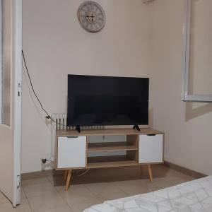 a flat screen tv on a stand in a living room at HOME away from home_3BR at Maniatika_14min walk to the port in Piraeus