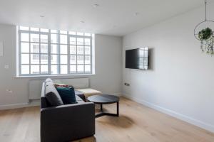 a living room with a couch and a tv at London's Calling - Farringdon - by Frankie Says in London