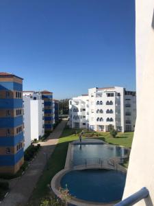 een uitzicht vanaf het balkon van een gebouw met een zwembad bij Puesta Del Sol in Asilah