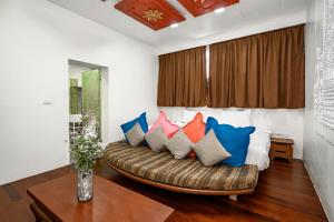 a living room with a couch with pillows on it at The Color Kata in Kata Beach