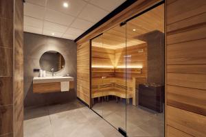 a bathroom with a glass shower and a sink at Van der Valk Hotel Leeuwarden in Leeuwarden