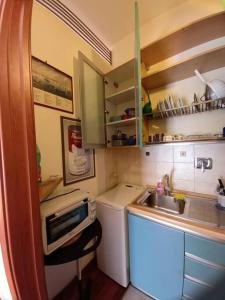 a small kitchen with a sink and a microwave at la casa del viaggiante in Rome